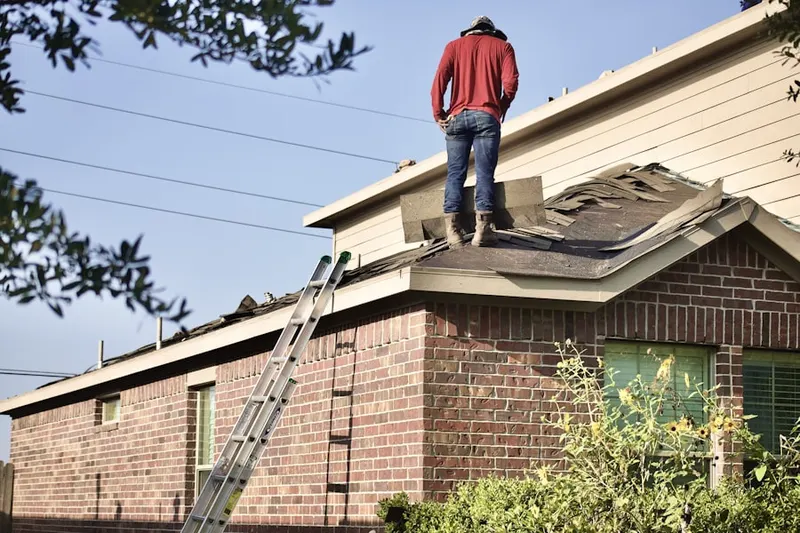 Professional roofer working on a residential roof in Ewing and Carroll